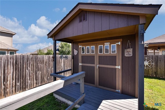 deck featuring an outbuilding, a storage unit, and fence