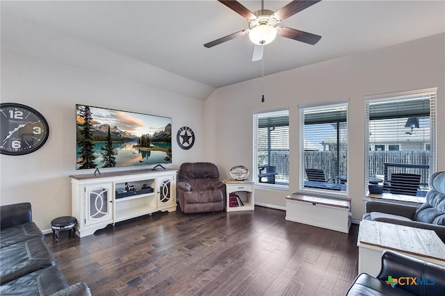 living area with baseboards, wood finished floors, ceiling fan, and vaulted ceiling