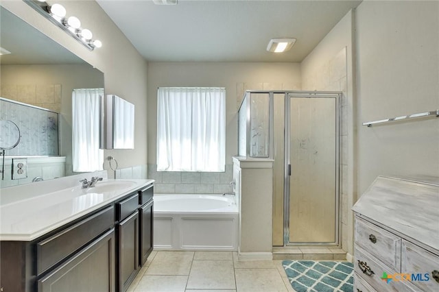 full bath with tile patterned flooring, a garden tub, vanity, and a stall shower