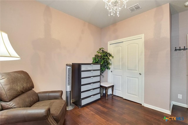 living area featuring visible vents, baseboards, a notable chandelier, and dark wood finished floors