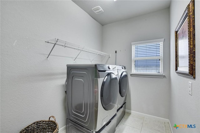 laundry area featuring light tile patterned floors, visible vents, baseboards, laundry area, and independent washer and dryer