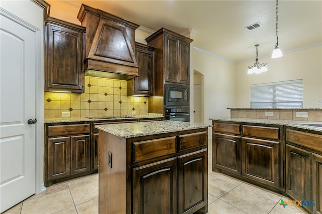 kitchen featuring a center island, dark brown cabinetry, hanging light fixtures, black appliances, and a notable chandelier