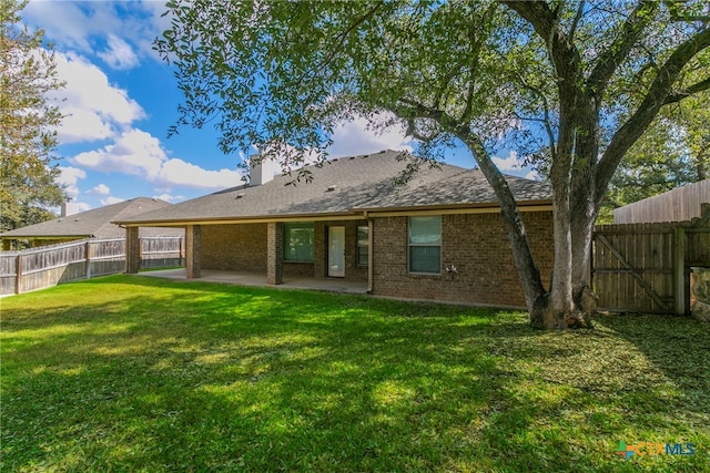 rear view of property featuring a patio area and a yard