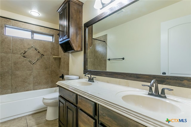 full bathroom featuring tile patterned flooring, vanity, tiled shower / bath combo, and toilet