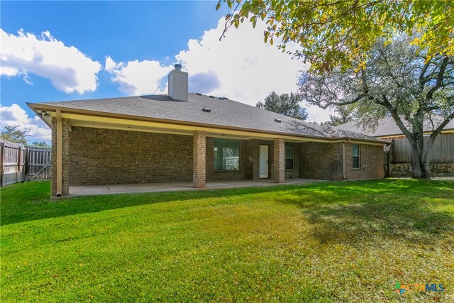 rear view of property with a lawn and a patio area