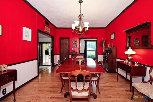 dining room featuring crown molding, a chandelier, and wood finished floors