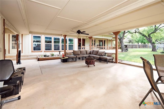 view of patio / terrace with a fenced backyard, a ceiling fan, and an outdoor living space with a fire pit