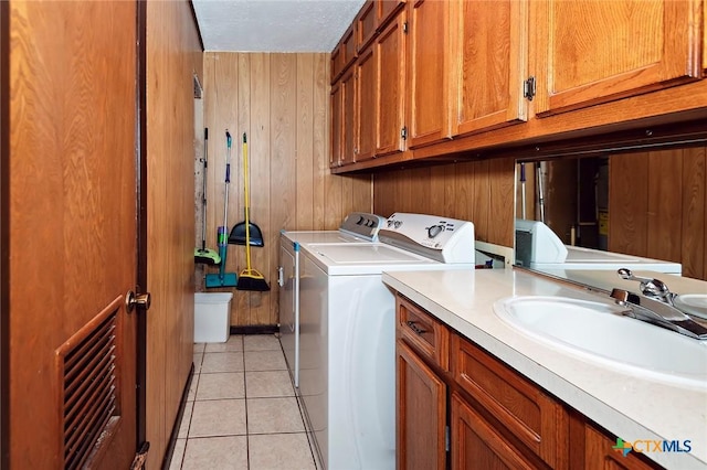 laundry area with separate washer and dryer, a sink, wooden walls, and light tile patterned floors