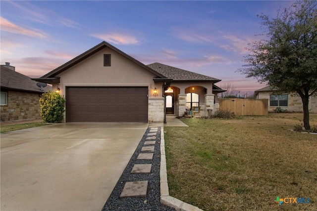 view of front of property with a garage and a yard