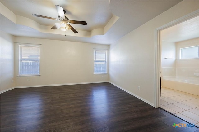 3907 Llano Estacado Ct, Killeen, TX 76549 - empty room with a ceiling fan, healthy amount of natural light, dark wood-type flooring, and a tray ceiling