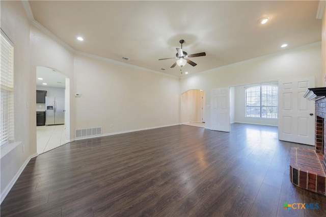3907 Llano Estacado Ct, Killeen, TX 76549 - unfurnished living room with arched walkways, ceiling fan, dark wood-style flooring, a fireplace, and ornamental molding