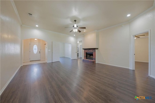 3907 Llano Estacado Ct, Killeen, TX 76549 - unfurnished living room featuring ceiling fan, ornamental molding, arched walkways, dark wood-type flooring, and a fireplace