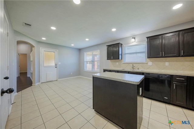 3907 Llano Estacado Ct, Killeen, TX 76549 - kitchen featuring dishwasher, arched walkways, a center island, tasteful backsplash, and light tile patterned floors