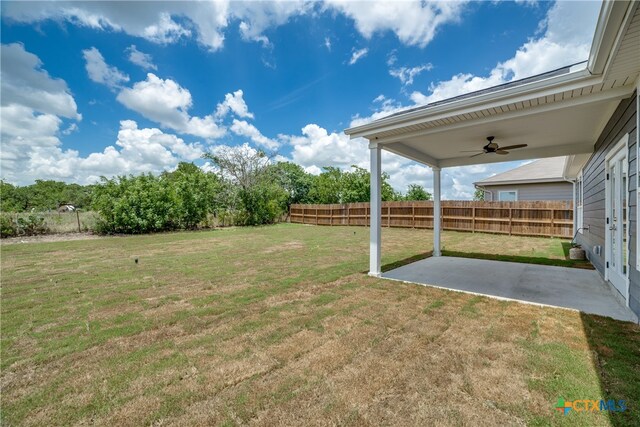 view of yard featuring ceiling fan and a patio