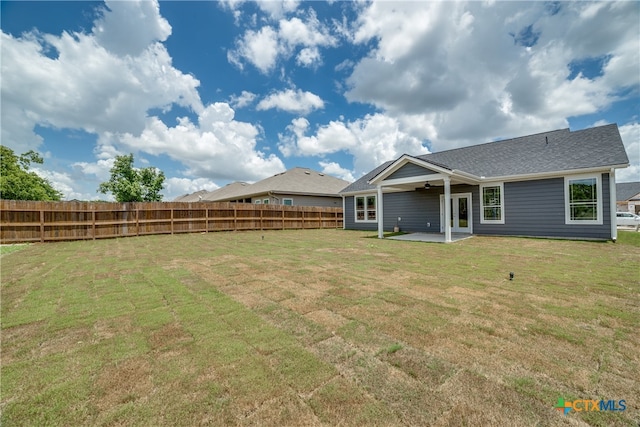 back of property featuring a patio area, ceiling fan, and a yard