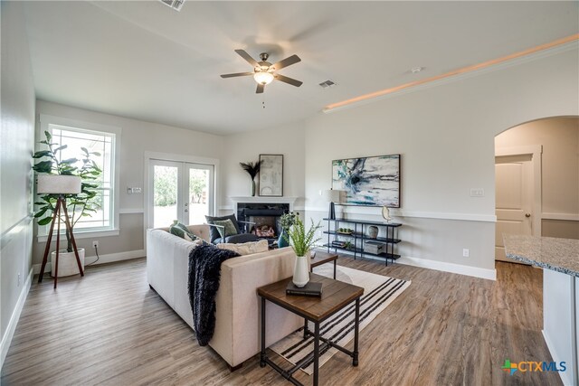 living room featuring french doors, light hardwood / wood-style floors, and ceiling fan