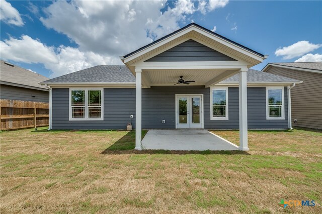 rear view of property with a patio area, ceiling fan, and a yard