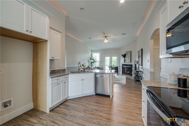 kitchen featuring white cabinets, appliances with stainless steel finishes, light hardwood / wood-style floors, and stone countertops