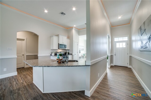 kitchen with white cabinetry, sink, dark wood-type flooring, stainless steel appliances, and ornamental molding