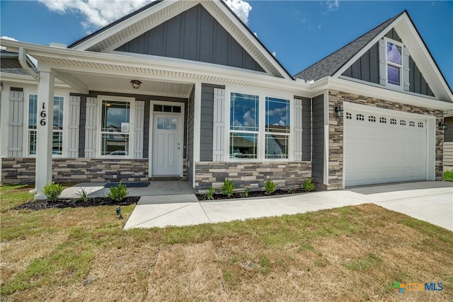 166 Lost Maples Way, Marion, TX 78124 - craftsman-style home with stone siding, board and batten siding, driveway, a front lawn, and an attached garage