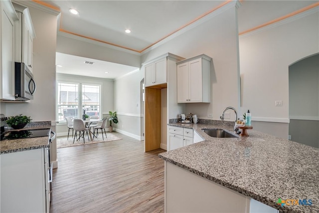 166 Lost Maples Way, Marion, TX 78124 - kitchen featuring stainless steel appliances, a sink, light stone counters, arched walkways, and crown molding