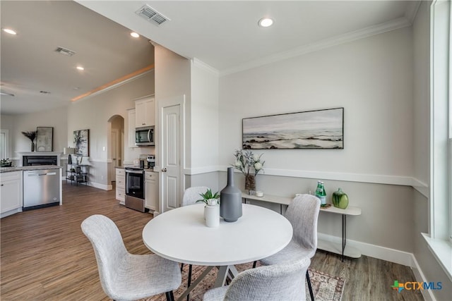 166 Lost Maples Way, Marion, TX 78124 - dining room with wood finished floors, arched walkways, crown molding, baseboards, and recessed lighting