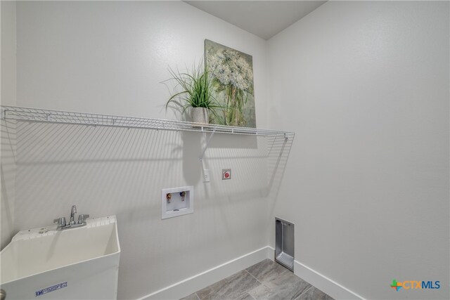 washroom featuring washer hookup, light tile patterned flooring, sink, and hookup for an electric dryer