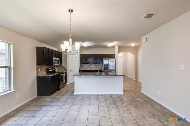 5402 Waterbank Ln, Killeen, TX 76543 - kitchen with appliances with stainless steel finishes, arched walkways, backsplash, a chandelier, and dark stone countertops