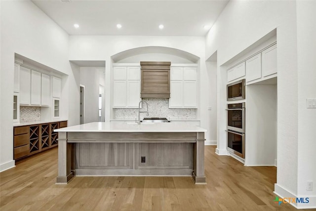 kitchen featuring white cabinetry, built in microwave, and a large island