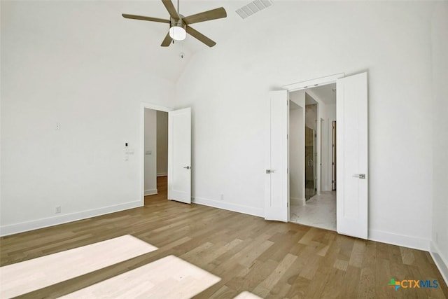 unfurnished bedroom with wood-type flooring, high vaulted ceiling, and ceiling fan