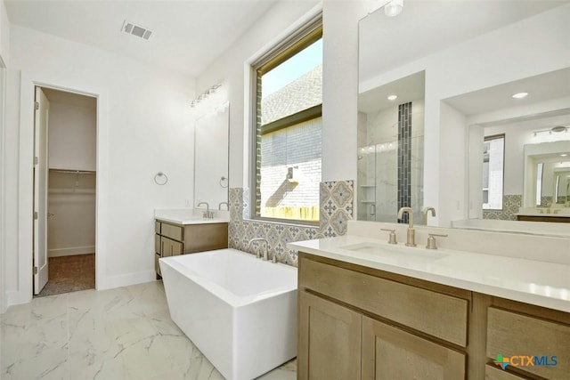 bathroom featuring decorative backsplash, vanity, separate shower and tub, and plenty of natural light