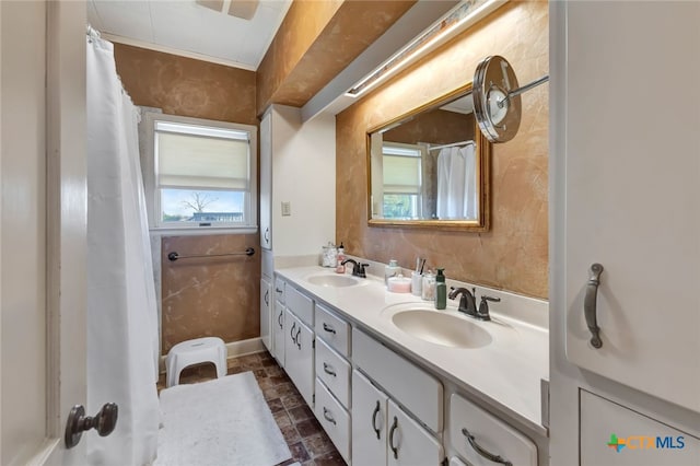 full bathroom featuring double vanity, stone finish flooring, and a sink