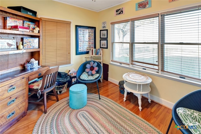 office area with baseboards, ornamental molding, and light wood finished floors