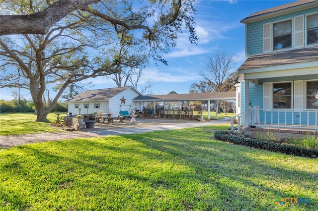 view of yard with a porch and an outdoor structure