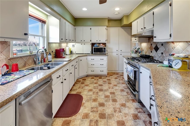 kitchen featuring under cabinet range hood, decorative backsplash, appliances with stainless steel finishes, white cabinets, and a sink