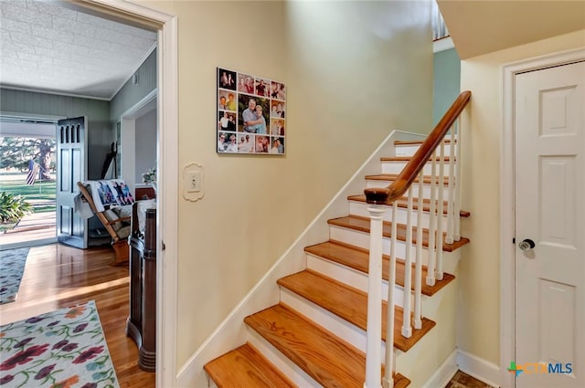 stairway with baseboards and wood finished floors