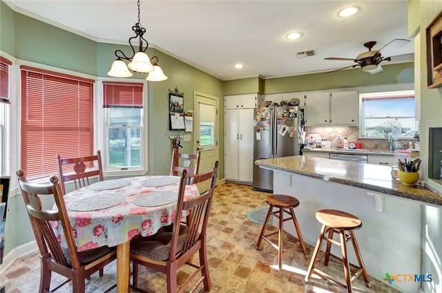 kitchen with visible vents, white cabinets, appliances with stainless steel finishes, a kitchen breakfast bar, and backsplash