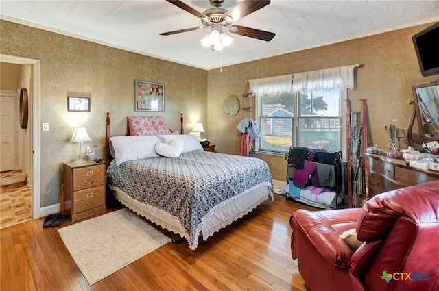 bedroom featuring ornamental molding, ceiling fan, baseboards, and hardwood / wood-style floors