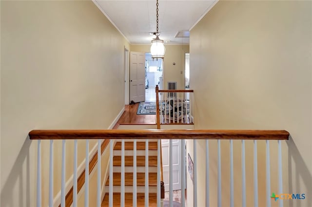 stairs with visible vents, ornamental molding, wood finished floors, baseboards, and attic access