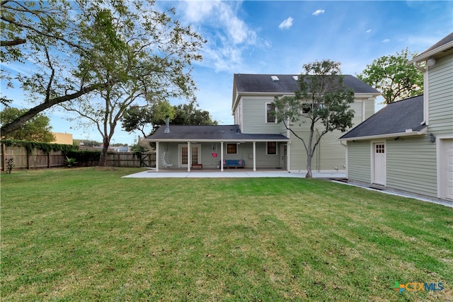 rear view of property with a lawn and a patio