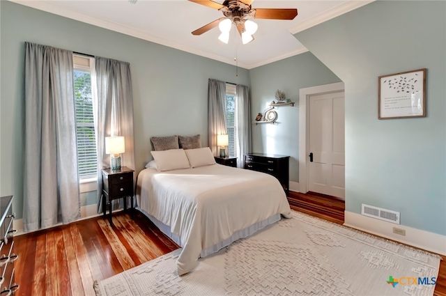 bedroom featuring ornamental molding, hardwood / wood-style floors, multiple windows, and ceiling fan