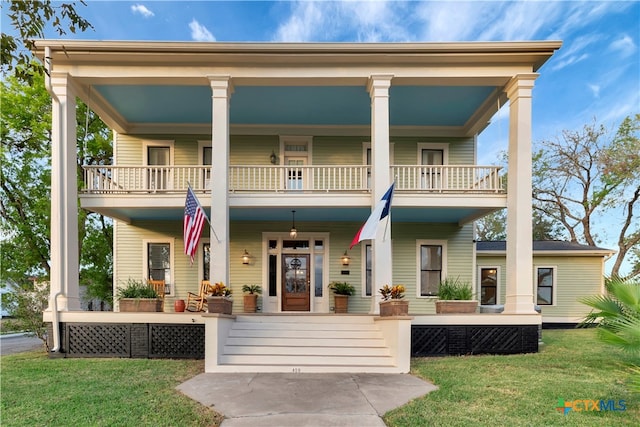 view of front of home featuring a porch, a front yard, and a balcony