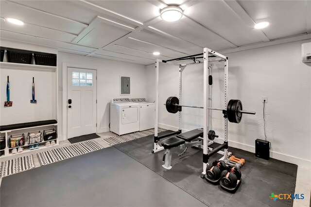 workout room featuring electric panel and washer and dryer