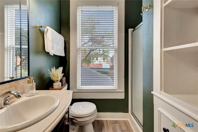 bathroom featuring hardwood / wood-style floors, an enclosed shower, vanity, and toilet