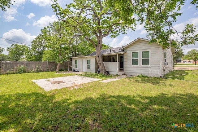 rear view of property featuring a fenced backyard, a patio, and a lawn