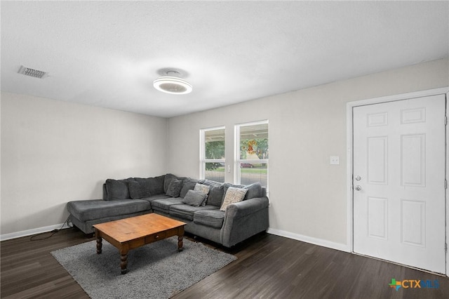 living area featuring visible vents, baseboards, and dark wood-type flooring
