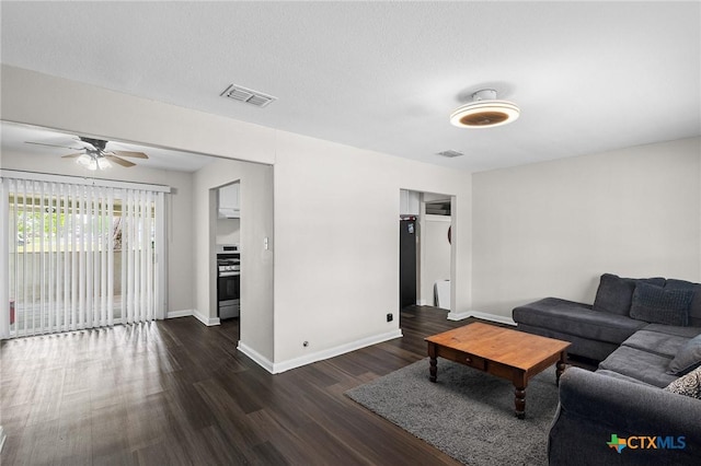 living area with visible vents, dark wood finished floors, ceiling fan, and baseboards