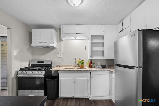 kitchen featuring under cabinet range hood, white cabinets, a sink, dark wood finished floors, and appliances with stainless steel finishes