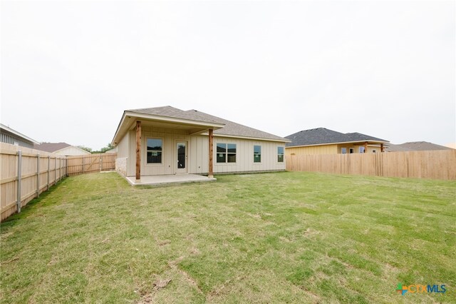 rear view of house with a lawn and a patio area