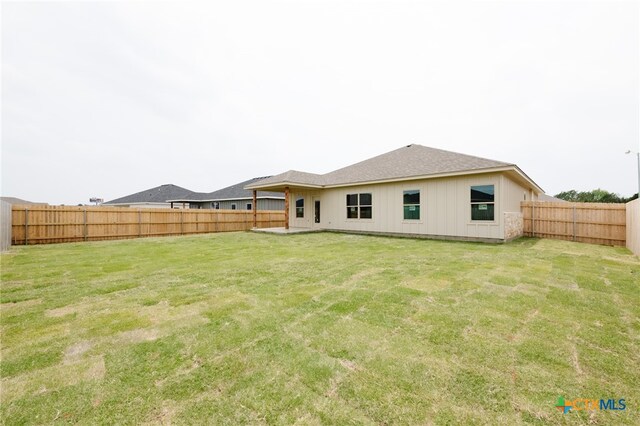 rear view of property with a lawn